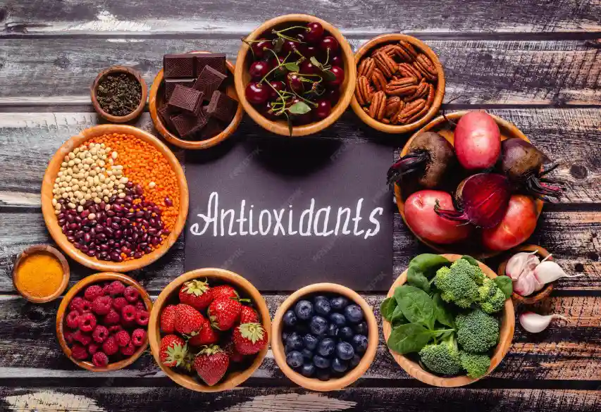 A diverse collection of natural antioxidant-rich foods including berries, seeds, and vegetables, surrounding an 'Antioxidants' sign, illustrating the nutritional support for athletic muscle recovery.