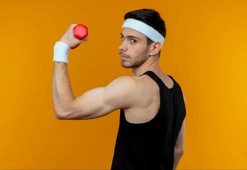 A fit young athlete flexing his bicep with a red dumbbell, representing optimal muscle function supported by potassium-rich pre-workout snacks.